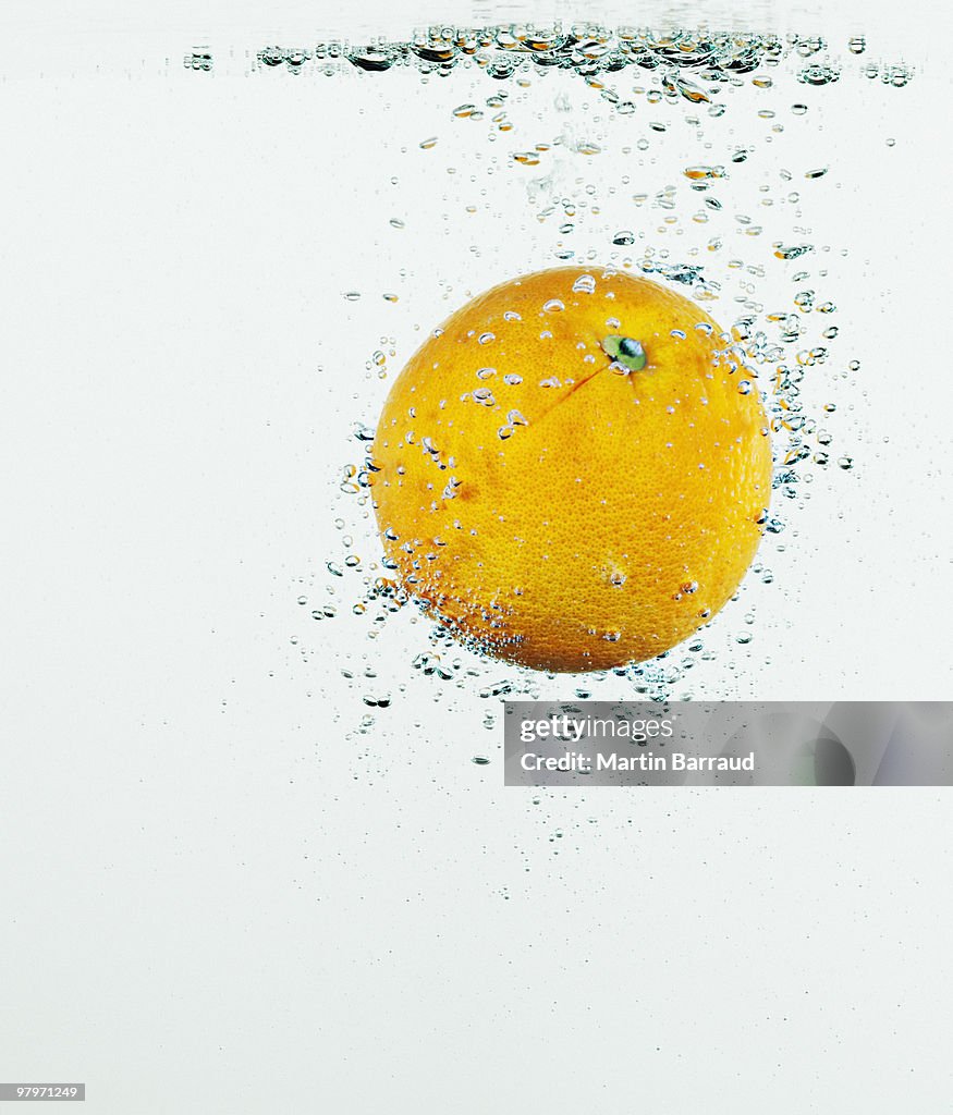 Primo piano di arancia spruzzi in acqua