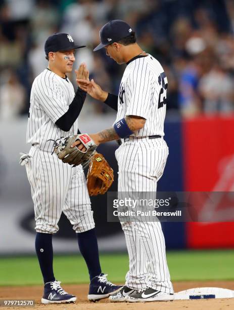 Ronald Torreyes and Gleyber Torres of the New York Yankees slap hands in the outfield as they celebrate the Yankees win after the last out of an MLB...