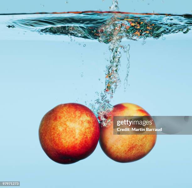 close up of apples splashing in water - wet juicy peach stock pictures, royalty-free photos & images