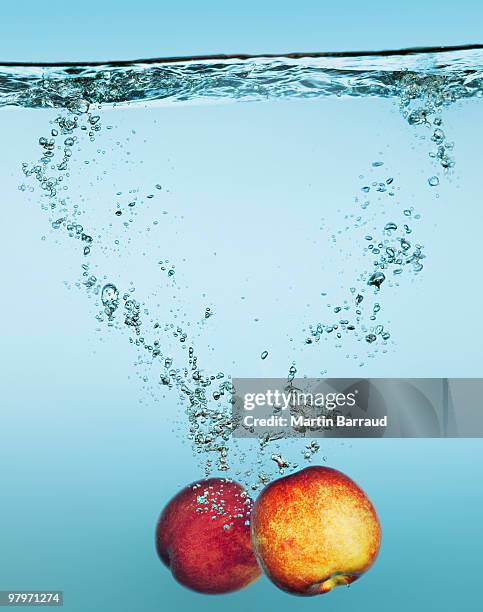 apples splashing in water - water apples stock pictures, royalty-free photos & images