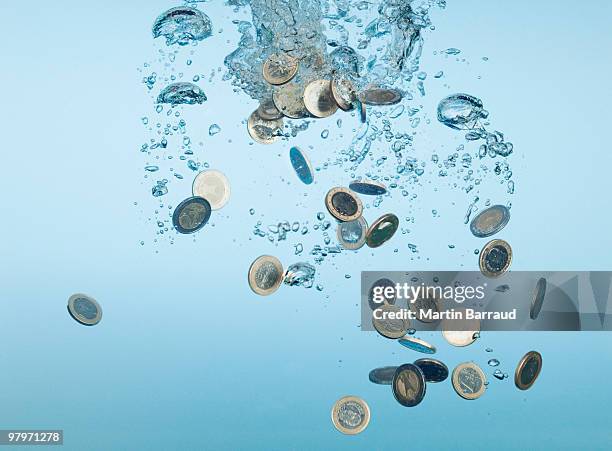 euro coins splashing in water - coins stockfoto's en -beelden