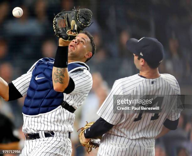 Catcher Gary Sanchez of the New York Yankees misplays an infield pop fly as Neil Walker looks on as the ball pops out of his mitt in an MLB baseball...