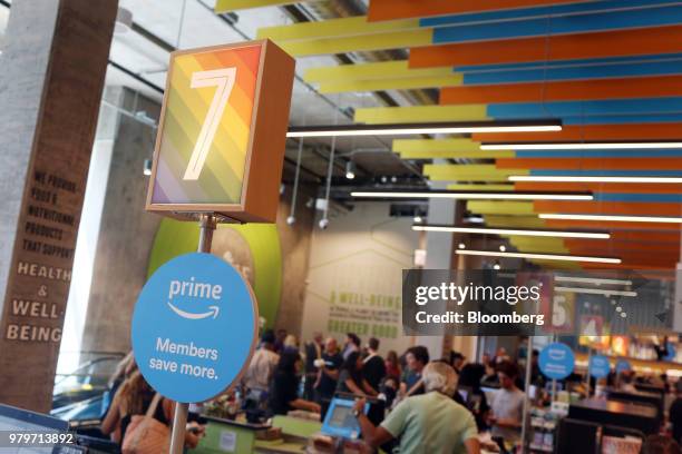 Sign for Amazon.com Inc. Prime members hangs on display at the check-out counter during the grand opening of a Whole Foods Market Inc. Location in...