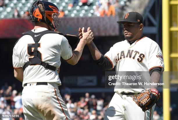 Reyes Moronta and Nick Hundley of the San Francisco Giants celebrates after they defeated the Miami Marlins 6-5 at AT&T Park on June 20, 2018 in San...