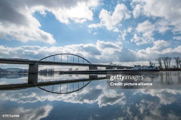 Dpatop - 08 March 2018, Germany, Deggendorf: An inland freighter passes underneath the bridge of the A92 motorway spanning across the Danube. Photo:...