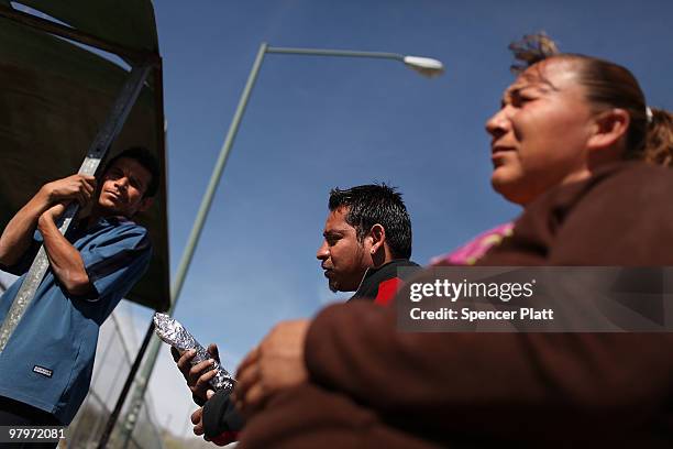 Bus drivers and food vendors wait for business in front of a maquiladora, or factory, on March 23, 2010 in Juarez, Mexico. Secretary of State Hillary...