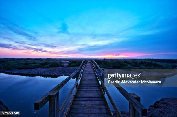 boardwalk over salt marsh, stiffkey, norfolk, england, uk - tidal marsh stock pictures, royalty-free photos & images