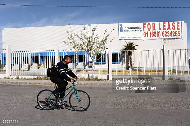 Man rides his bike by a closed maquiladora, or factory, on March 23, 2010 in Juarez, Mexico. Secretary of State Hillary Rodham Clinton, Defense...