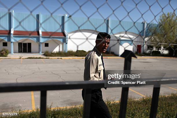 Security guard waits in front of a closed maquiladora, or factory, on March 23, 2010 in Juarez, Mexico. Secretary of State Hillary Rodham Clinton,...