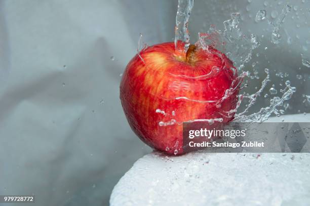 red apple in splash of water - apple water splashing stock pictures, royalty-free photos & images