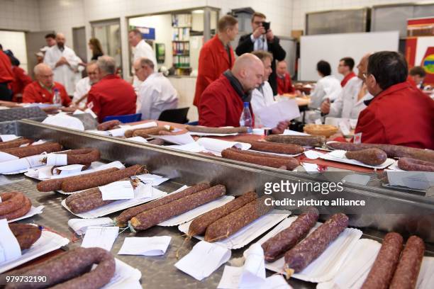 March 2018, Germany, Kassel: Testers sitting in front of Ahlen sausages at a table and are evaluating the products. The testers are searching for the...
