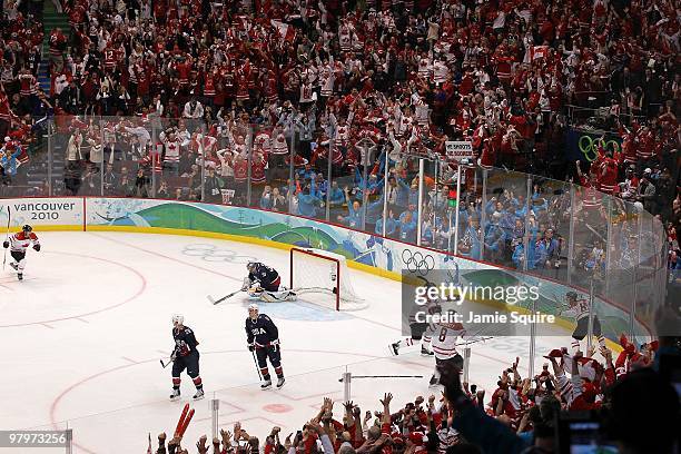 Sidney Crosby of Canada waits to celebrate in the corner with teammates after scoring the game-winning goal in overtime against Ryan Miller of USA in...