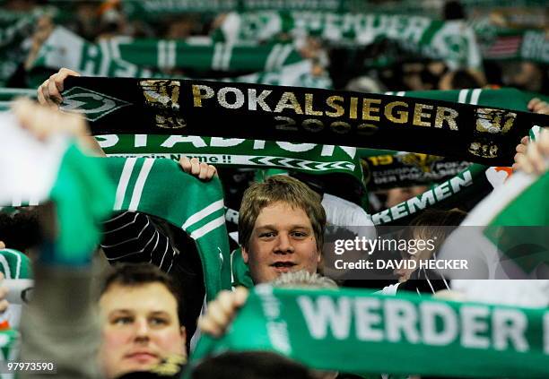 Werder Bremen supporters wave scarves ass they cheer their team before the DFB German Cup semi-final football match Werder Bremen vs FC Augsburg in...