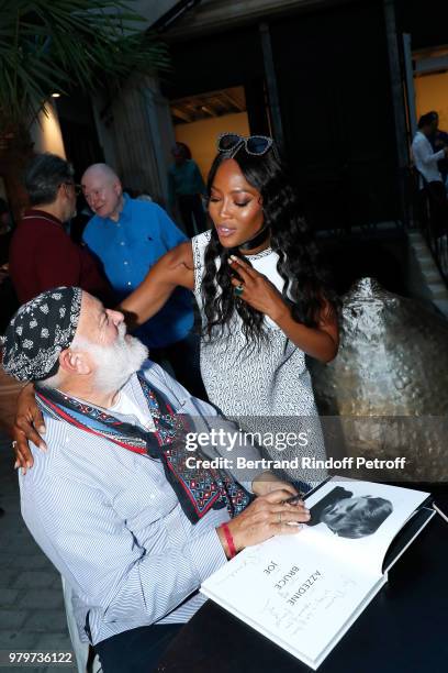 Bruce Weber signs the book for model Naomi Campbell during photographer Bruce Weber signs the book "Azzedine, Bruce and Joe" at Galerie Azzedine...