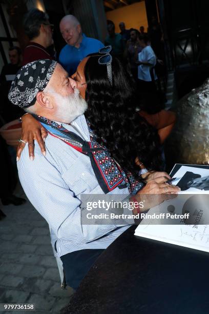 Bruce Weber signs the book for model Naomi Campbell during photographer Bruce Weber signs the book "Azzedine, Bruce and Joe" at Galerie Azzedine...