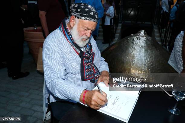 Bruce Weber signs the book for model Naomi Campbell during photographer Bruce Weber signs the book "Azzedine, Bruce and Joe" at Galerie Azzedine...