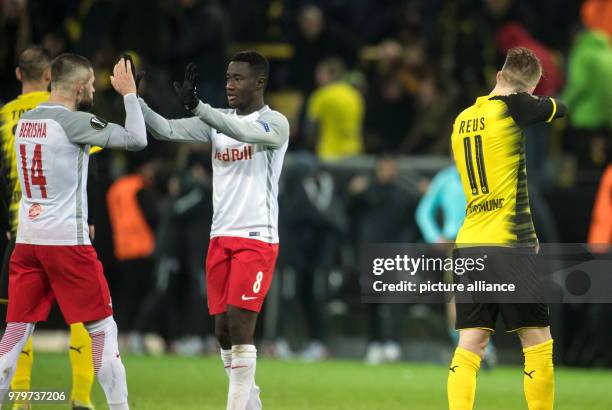 Dortmund's Marco Reus turns away while Salzburg's Valon Berisha and Diadie Samassekou celebrate their victory after the final whistle of the UEFA...