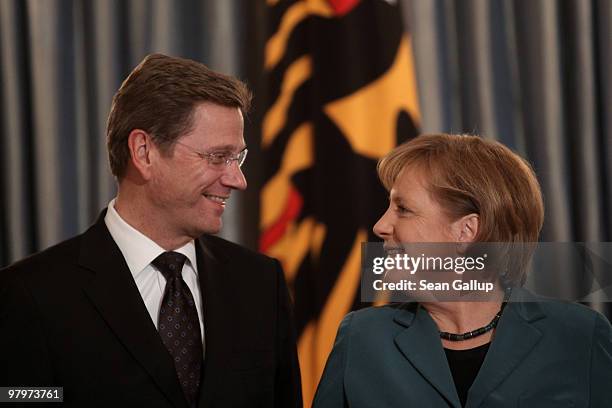 German Chancellor Angela Merkel and Vice Chancellor and Foreign Minister Guido Westerwelle arrive for a dinner at Schloss Bellevue Palace on March...