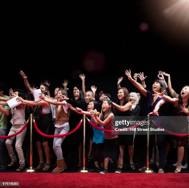 screaming fans on the red carpet - barrera de cuerda fotografías e imágenes de stock