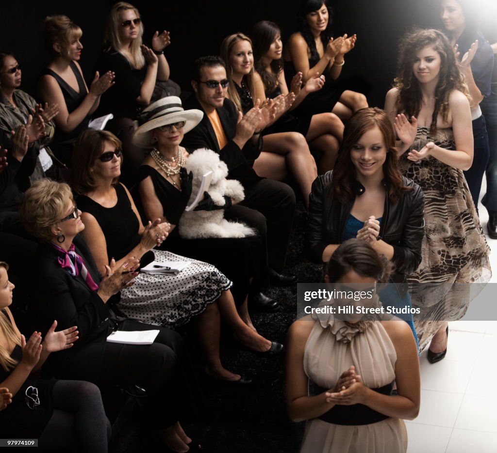 Models clapping on runway at fashion show