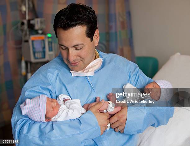 hispanic man holding newborn babies - father with twins stock pictures, royalty-free photos & images