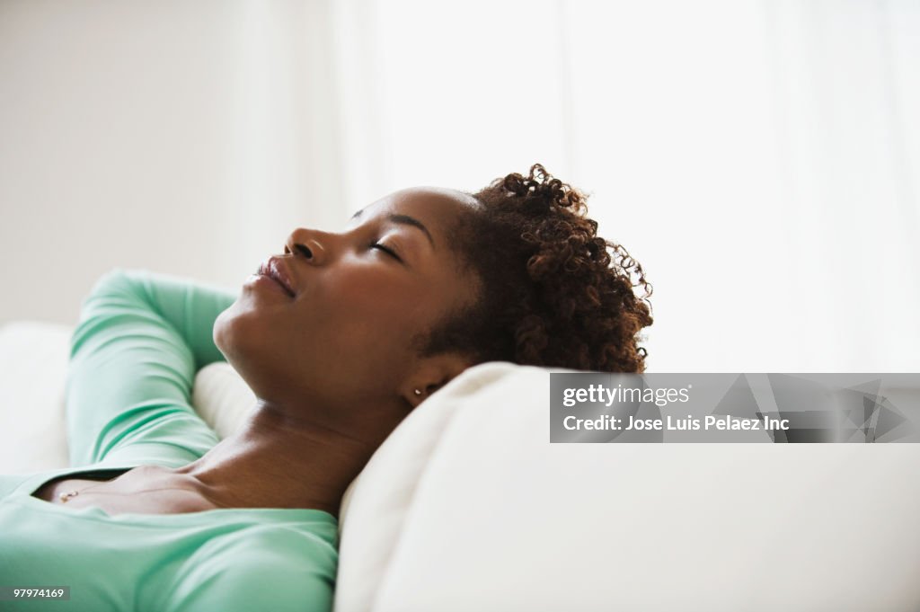 African woman napping on sofa