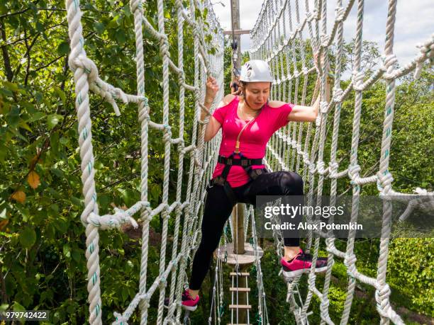 la mujer adulta pasando por la línea de zip. foto de móvil. - alex potemkin or krakozawr fotografías e imágenes de stock