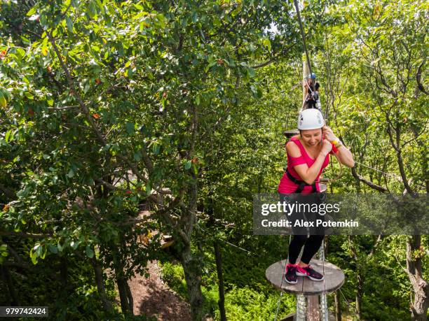 la mujer adulta pasando por la línea de zip. foto de móvil. - alex potemkin or krakozawr fotografías e imágenes de stock