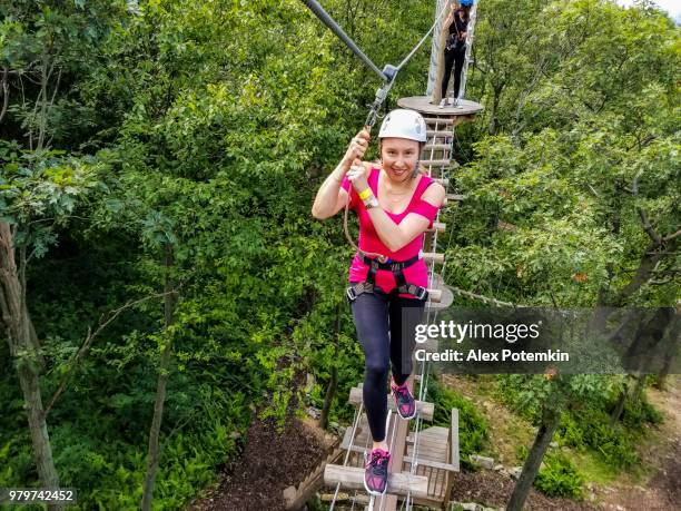 la mujer adulta pasando por la línea de zip. foto de móvil. - alex potemkin or krakozawr fotografías e imágenes de stock