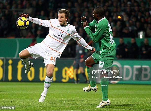 Philipp Bargfrede of Bremen and Andrew Sinkala of Augsburg compete for the ball during the DFB Cup Semi Final match between SV Werder Bremen and FC...