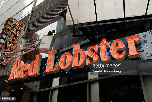 Greg Niem, a sign electrician with Spectrum on Broadway, works on the neon sign outside a Red Lobster restaurant in Times Square, New York, U.S., on...