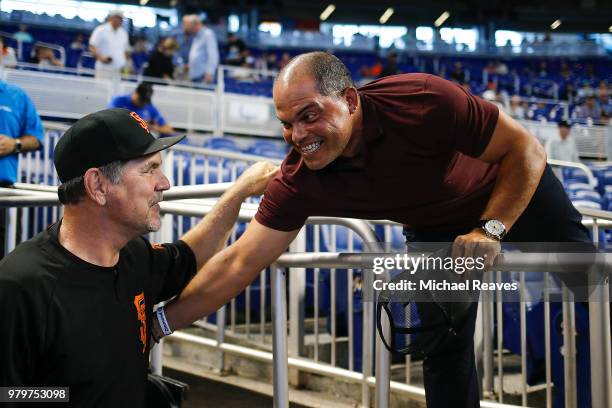 Manager Bruce Bochy of the San Francisco Giants greets former Florida Marlins catcher Ivan 'Pudge' Rodriguez prior to the game at Marlins Park on...