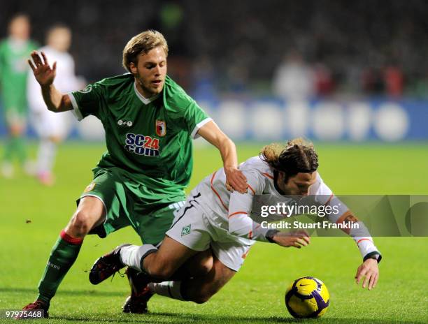 Torsten Frings of Bremen is challenged by Daniel Brinkmann of Augsburg during the DFB cup semi final match between SV Werder Bremen and FC Augsburg...