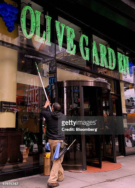Leo Rodriguez, a window washer with Reliable Window Cleaning, cleans the glass outside an Olive Garden restaurant in Times Square, New York, U.S., on...