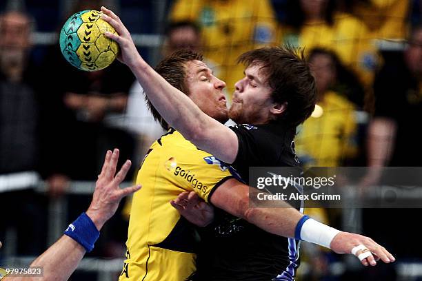 Kristian Nippes of Dormagen is challenged by Oliver Roggisch of Rhein-Neckar Loewen during the Toyota Bundesliga match between Rhein-Neckar Loewen...