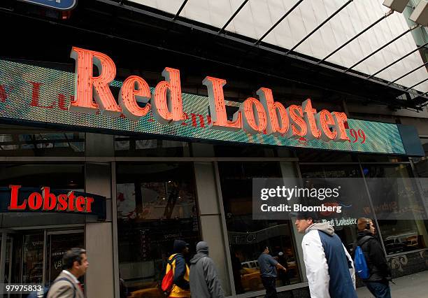 Pedestrians pass a Red Lobster restaurant in Times Square, New York, U.S., on Tuesday, March 23, 2010. Darden Restaurants Inc., the owner of casual...