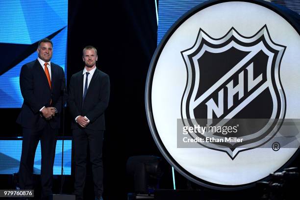 Hockey Hall of Fame member Eric Lindros and Daniel Sedin of the Vancouver Canucks present an award onstage at the 2018 NHL Awards presented by Hulu...