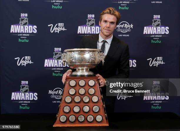 Connor McDavid of the Edmonton Oilers poses with the Art Ross Trophy as the NHL's leading scorer in the press room at the 2018 NHL Awards presented...