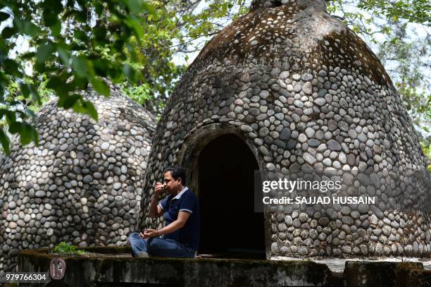 This picture taken on June 18 a tourist meditates at the now-derelict ashram attended by The Beatles 50 years ago in Rishikesh in India's -...