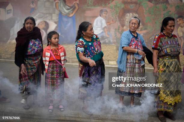 Indigenous women burn incense, as the truck transporting 172 urns containing the remains of victims of the Guatemalan armed conflict , arrives in San...