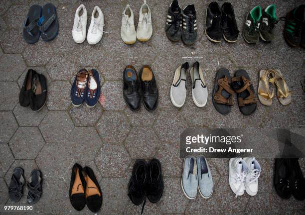 Activists leave their shoes on the ground to represent refugees during a rally to support immigrants and to mark World Refugee Day, June 20, 2018 in...