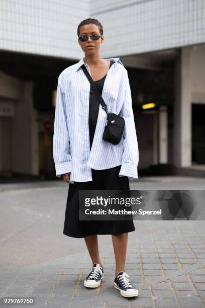 Guest is seen on the street during Paris Men's Fashion Week S/S 2019 wearing an oversized striped shirt with black cross-body bag on June 20, 2018 in...