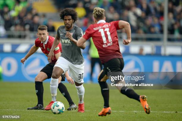 March 2018, Hanover, Germany: Bundesliga football, Hannover 96 vs FC Augsburg at the HDI-Arena. Augsburg's Caiuby in action against Hannover's Felix...