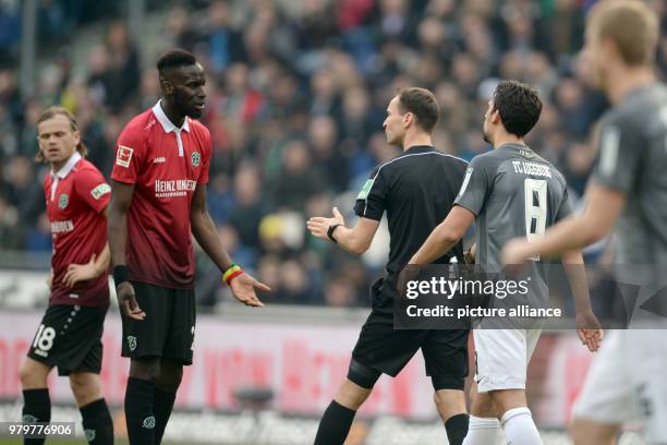 March 2018, Hanover, Germany: Bundesliga football, Hannover 96 vs FC Augsburg at the HDI-Arena. Hannover's Salif Sane speaking with referee Bastian...