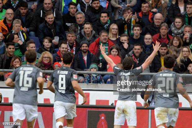 March 2018, Hanover, Germany: Bundesliga football, Hannover 96 vs FC Augsburg at the HDI-Arena. Augsburg's Michael Gregoritsch celebrates with fans...