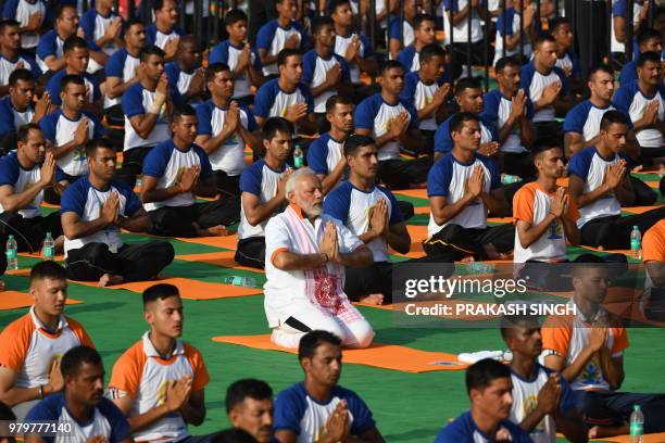 Indian Prime Minister Narendra Modi participates in a mass yoga session along with other practitioners to mark International Yoga Day at the Forest...