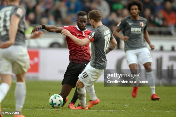 Hannover's Salif Sane and Augsburg's Daniel Baier battle for the ball during the German Bundesliga soccer match between Hannover 96 and FC Augsburg...