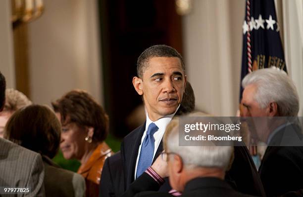 President Barack Obama talks to attendees after signing the health insurance reform bill in the East Room of the White House in Washington, D.C.,...