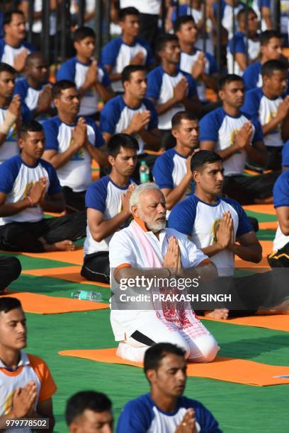 Indian Prime Minister Narendra Modi participates in a mass yoga session along with other practitioners to mark International Yoga Day at the Forest...