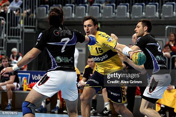 Michael Mueller of Rhein-Neckar Loewen is challenged by Spyros Balomenos and Florian Wisotzki of Dormagen during the Toyota Bundesliga match between...